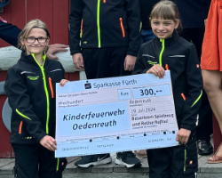 Spendenuebergabe an die Kinderfeuerwehr Oedenreuth durch den Spielzeugbasar Rosstal - Zwei Kinder halten den Scheck über 300 EUR